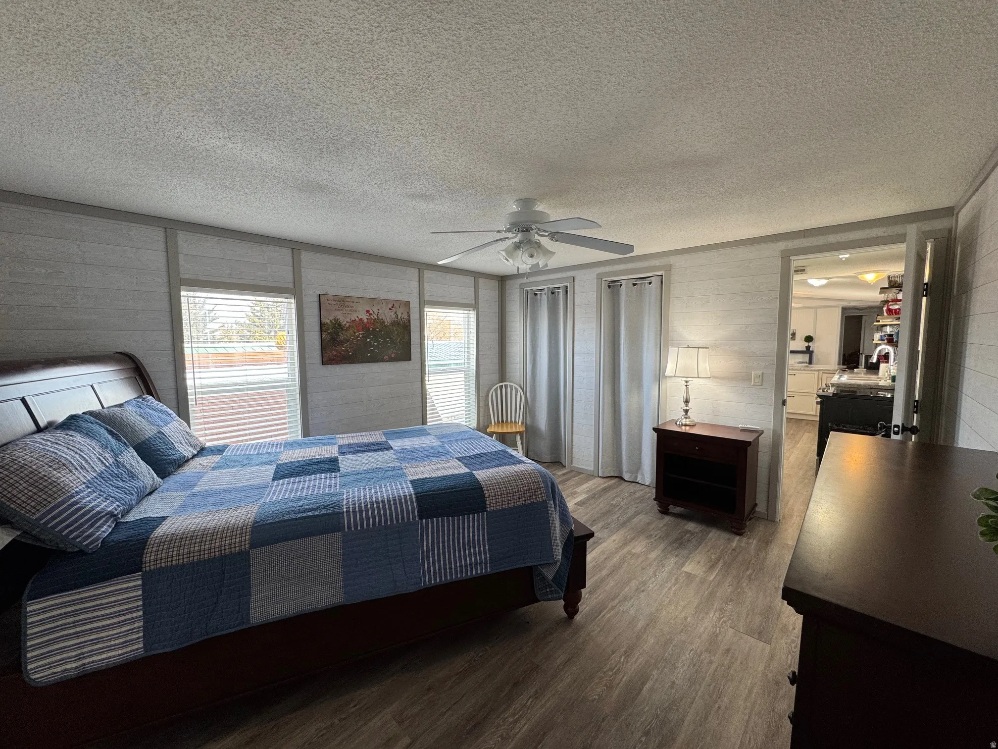 Bedroom featuring dark wood finished floors, a ceiling fan, and a textured ceiling