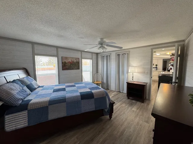 Bedroom featuring dark wood finished floors, a ceiling fan, and a textured ceiling