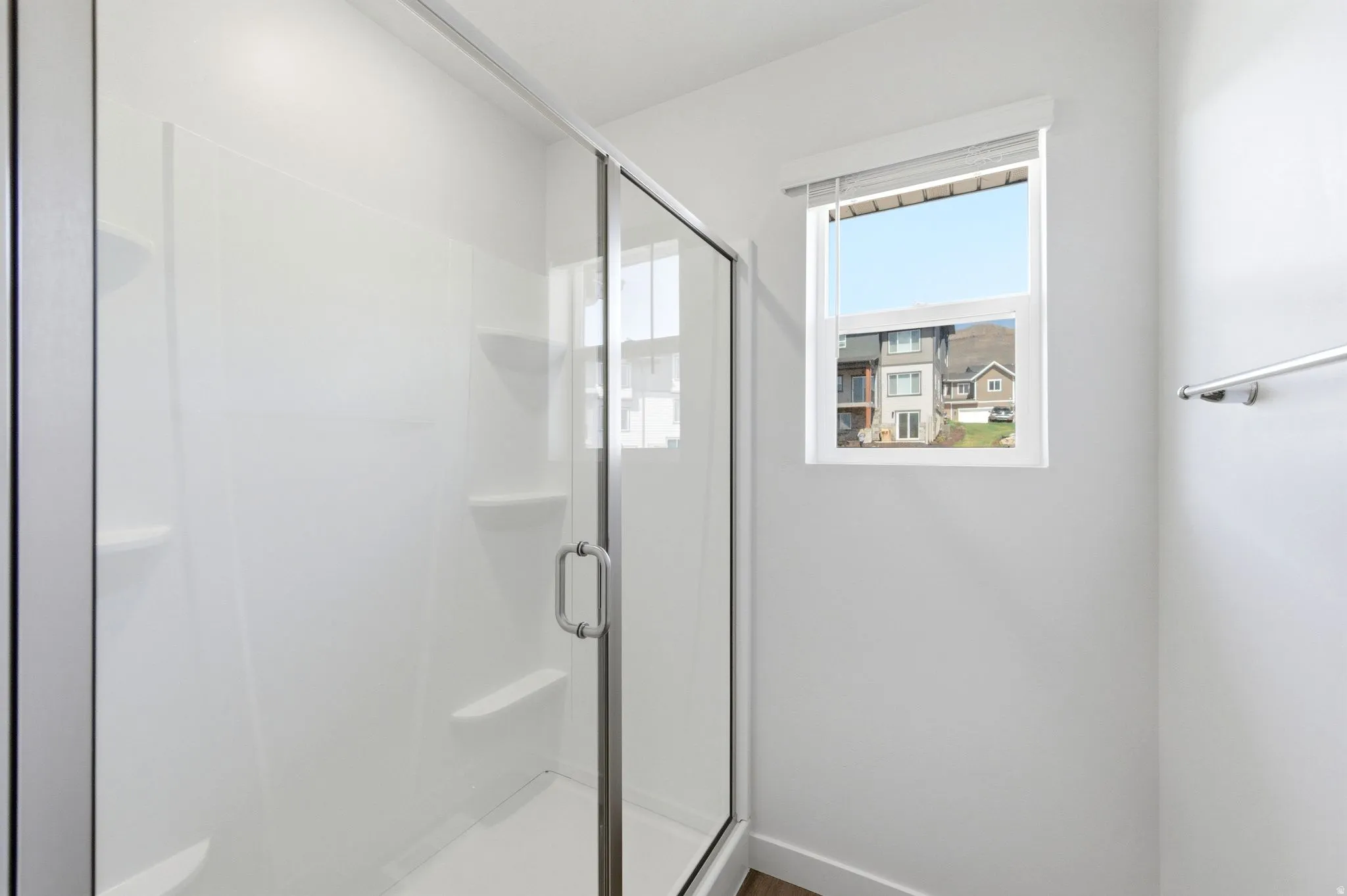 Bathroom with a shower stall and baseboards
