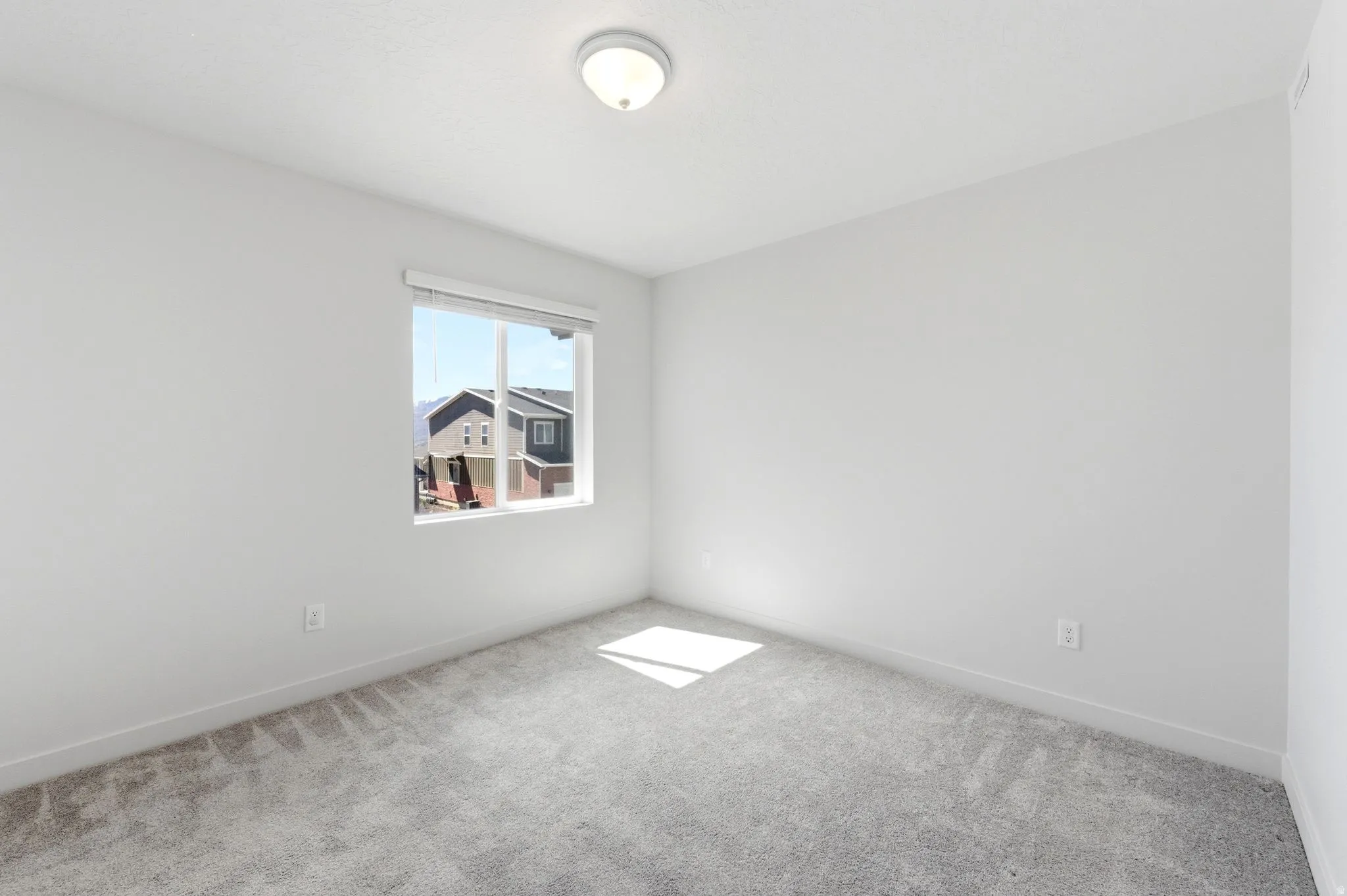 Spare room with light carpet and baseboards