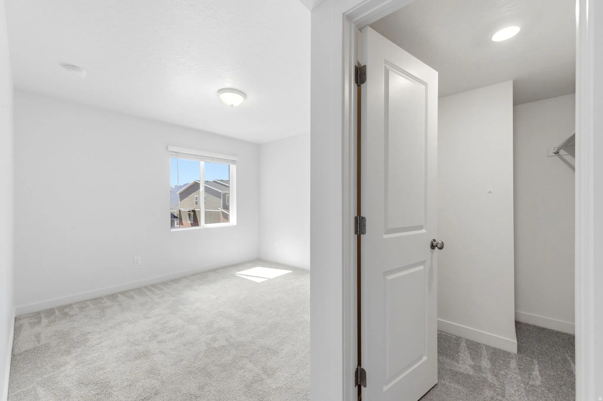 Unfurnished bedroom featuring light carpet and baseboards