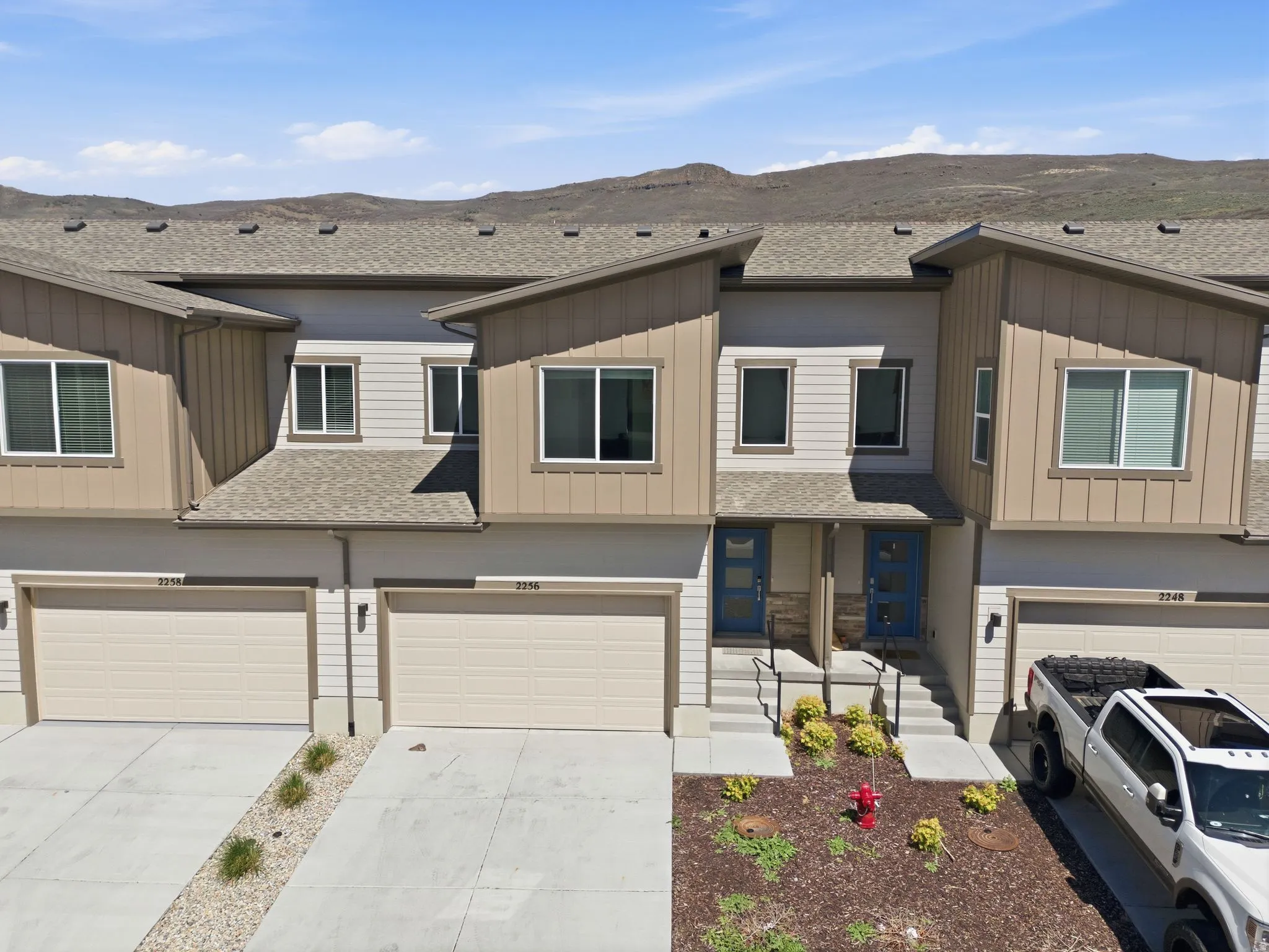 View of front of property with roof with shingles, board and batten siding, a garage, and concrete driveway