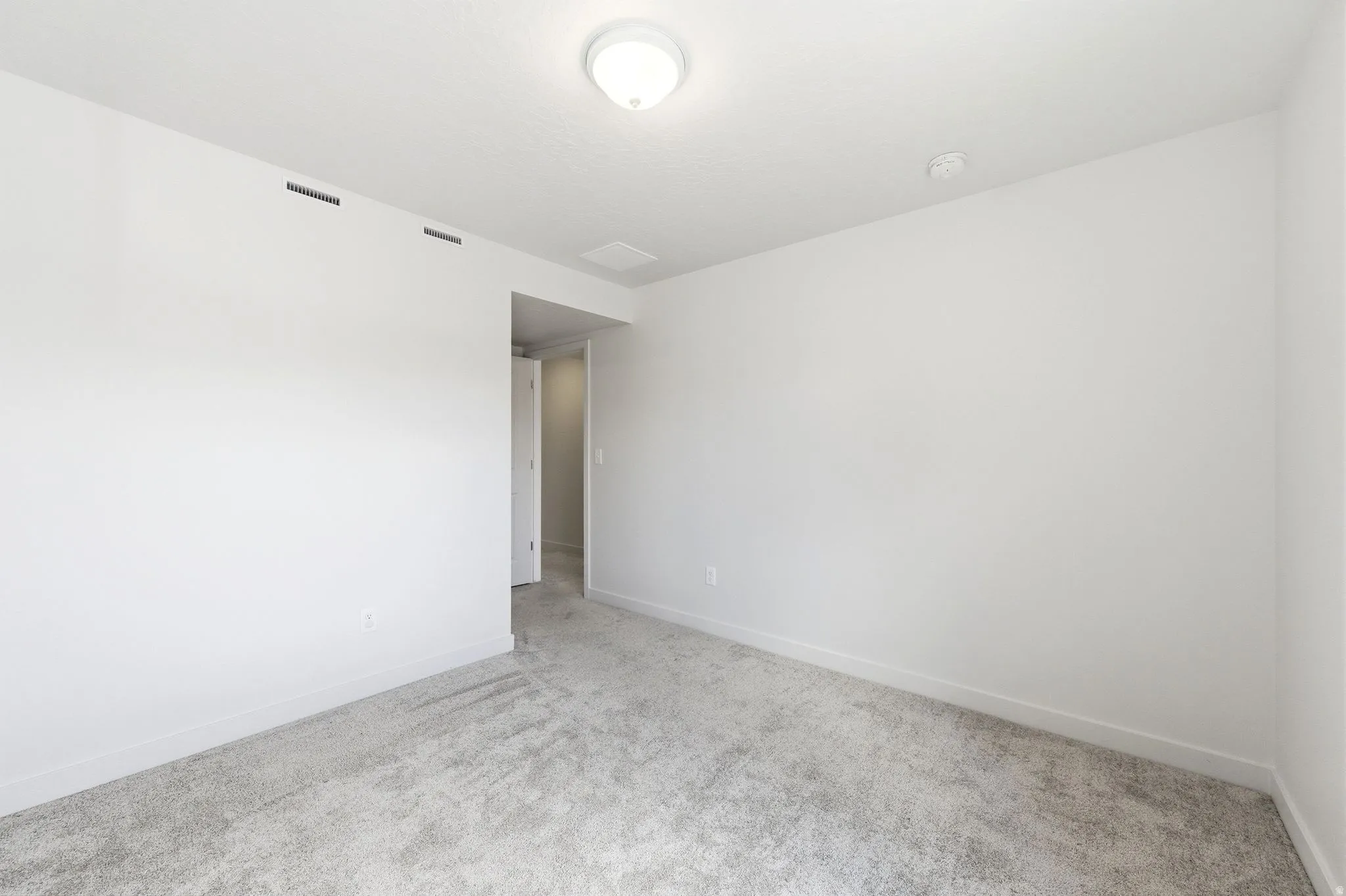 Empty room featuring carpet and baseboards