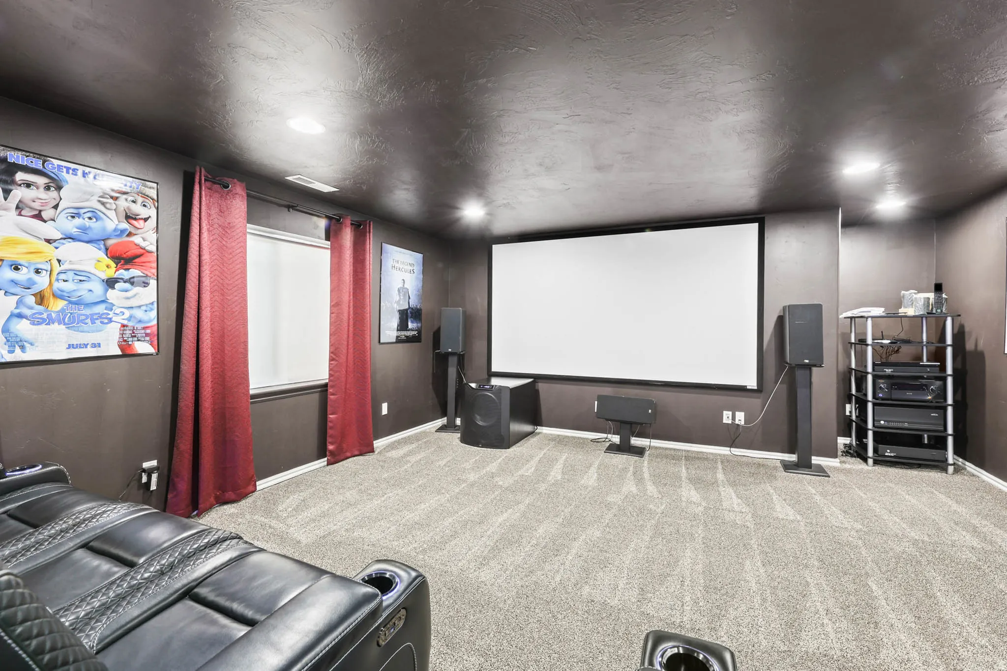 Carpeted cinema room with a textured ceiling and baseboards