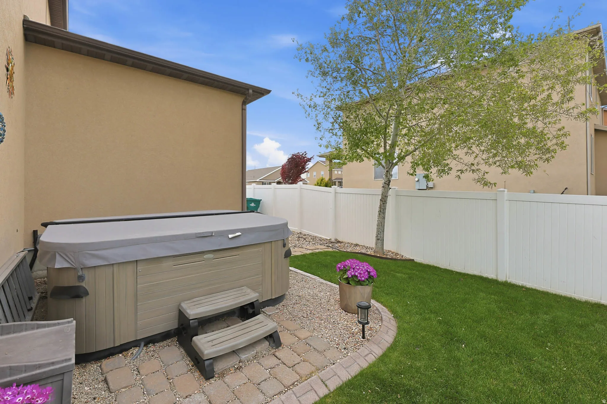 Fenced backyard featuring a patio and a hot tub