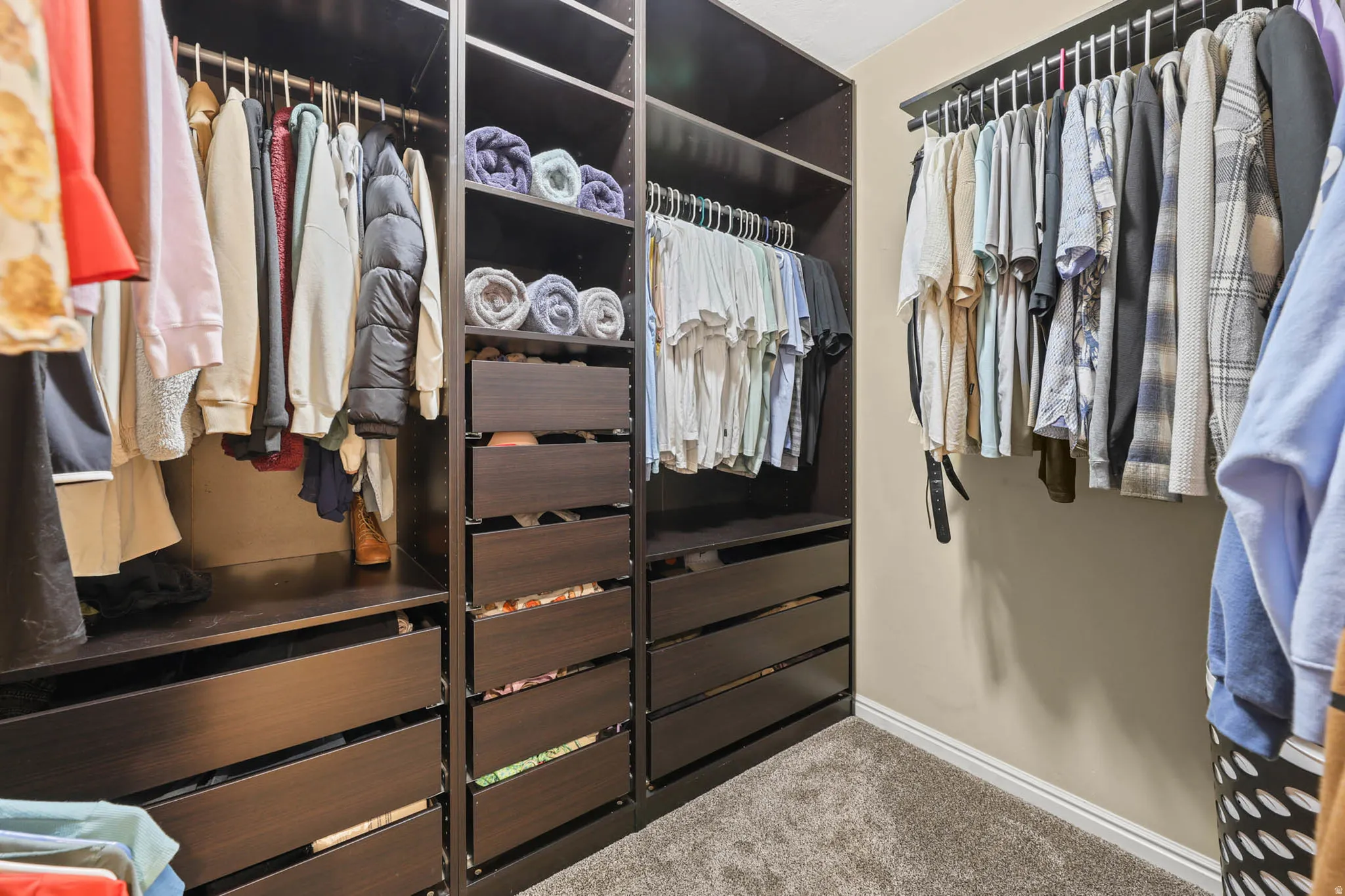 Walk in closet with built in storage and carpet floors