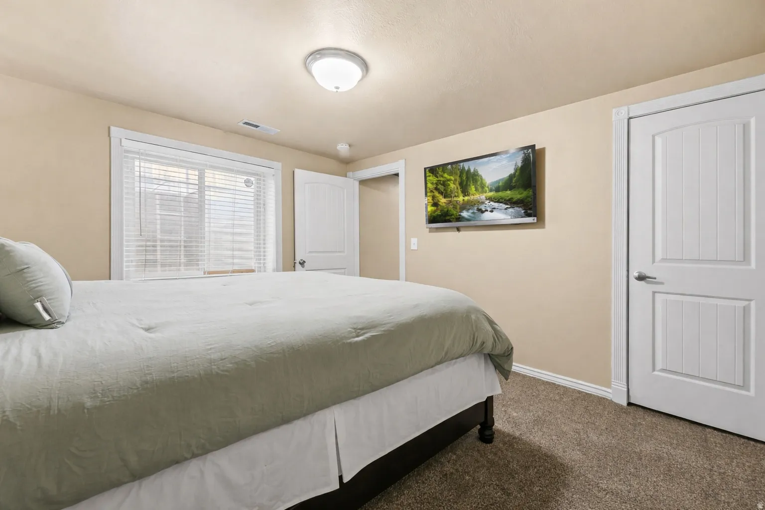 Bedroom with dark colored carpet and baseboards