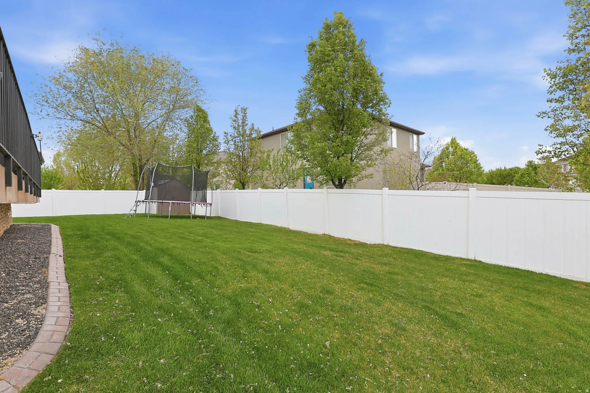 Fenced backyard with a trampoline