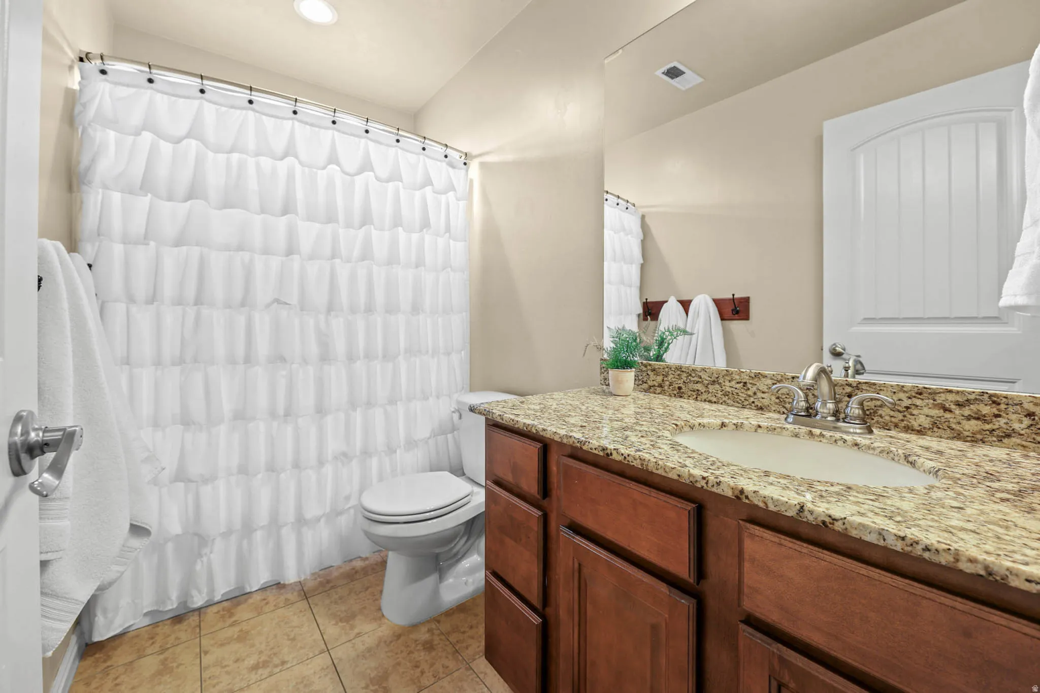 Full bathroom with vanity, a shower with shower curtain, light tile patterned floors, and recessed lighting