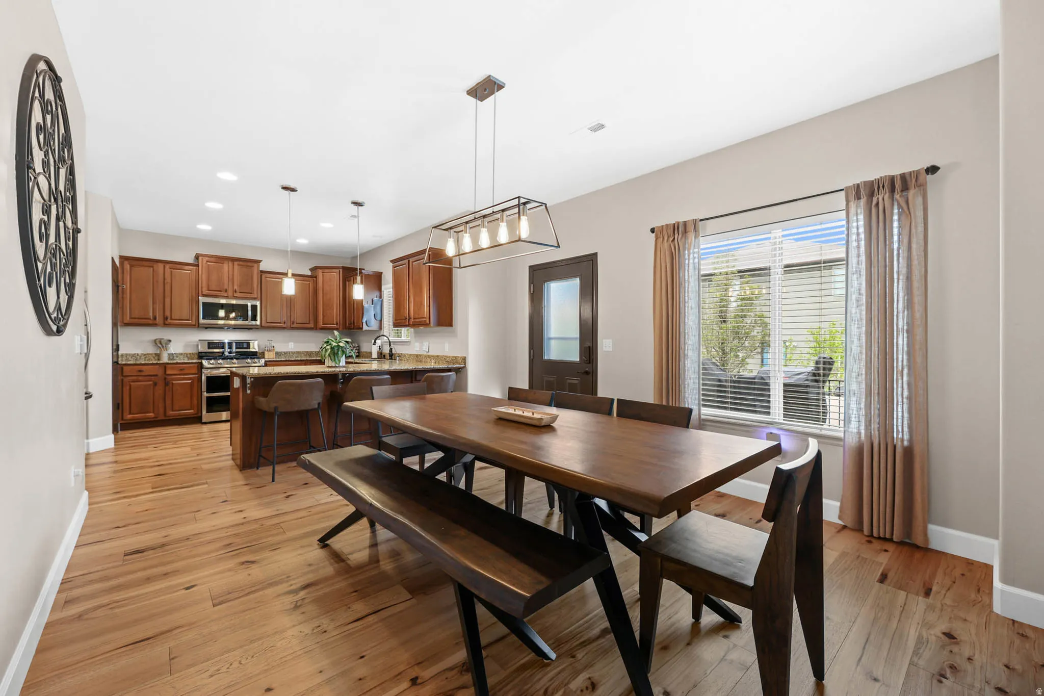 Dining space with engineered hardwood flooring and recessed lighting