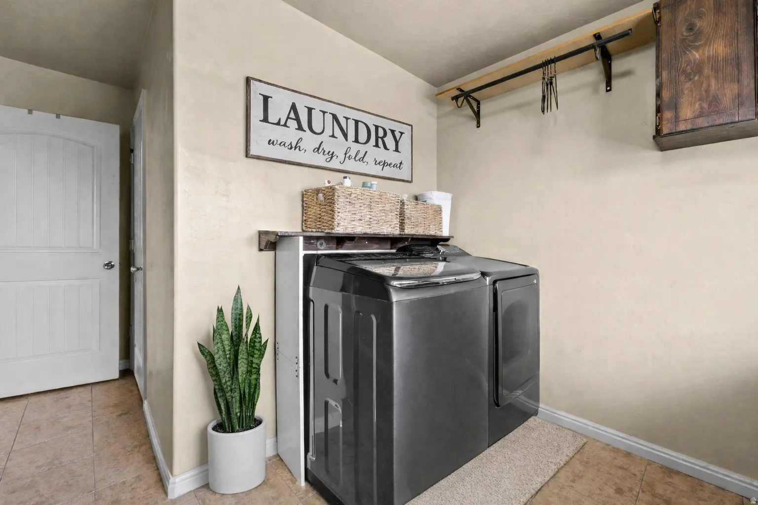 Laundry room featuring separate washer and dryer and light tile patterned flooring