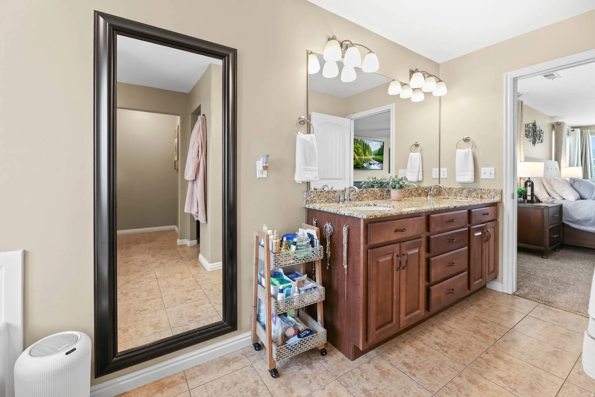 Full bathroom featuring ensuite bath, double vanity, and light tile patterned floors