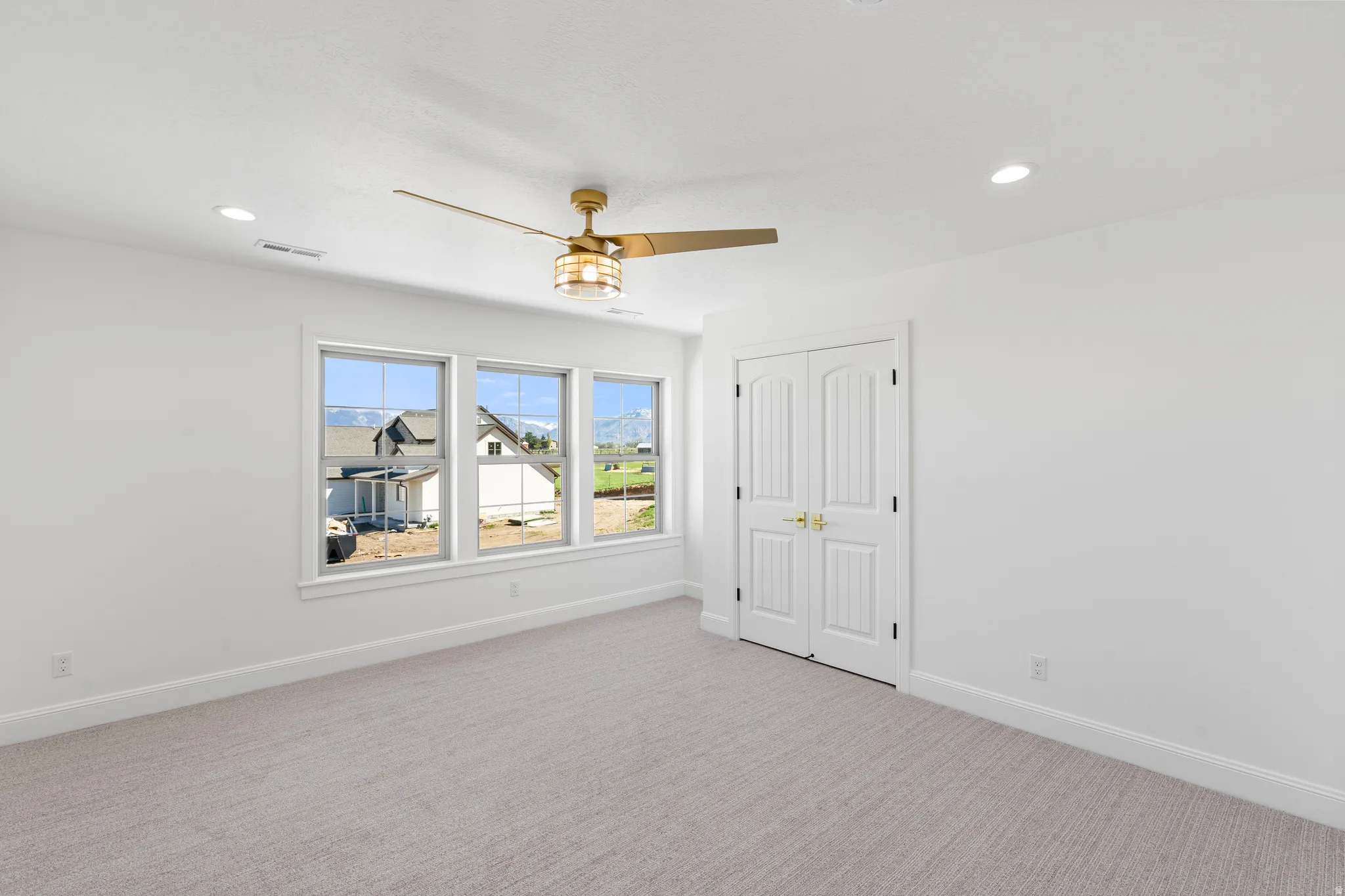 Unfurnished bedroom with carpet, ceiling fan, a closet, and recessed lighting