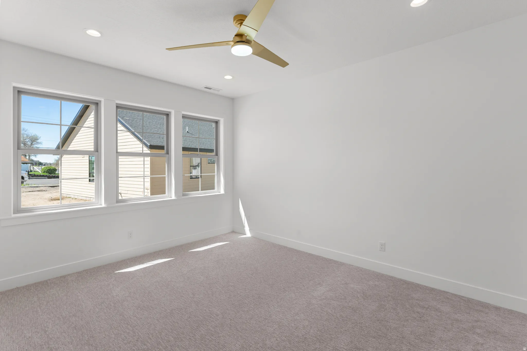 Empty room featuring carpet, ceiling fan, and recessed lighting