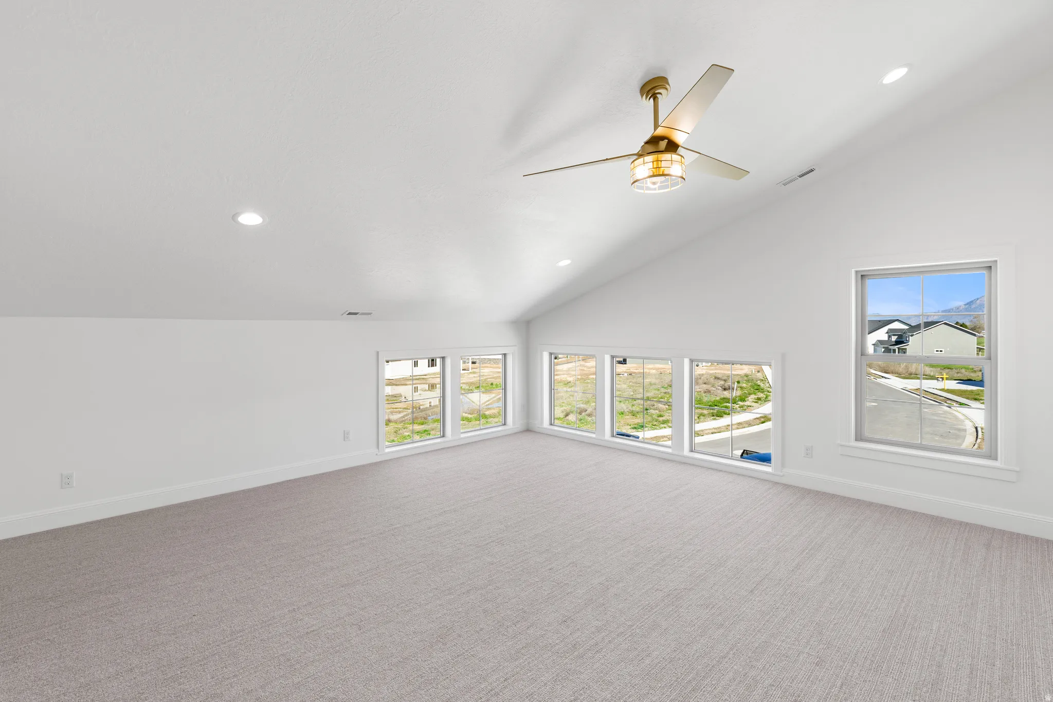 Unfurnished living room with carpet, recessed lighting, a ceiling fan, and vaulted ceiling