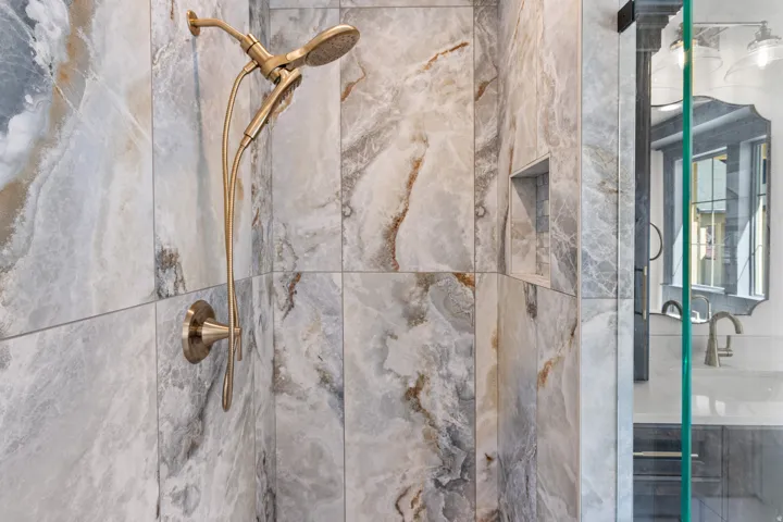 Bathroom view of a marble finish shower and vanity