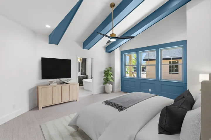 Bedroom with ceiling fan, carpet, vaulted ceiling with beams, and ensuite bath