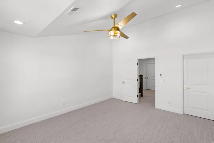 Unfurnished bedroom with recessed lighting, carpet flooring, a ceiling fan, and vaulted ceiling