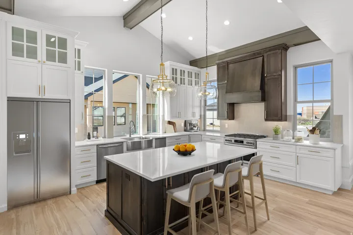 Dual tone kitchen with stainless steel appliances, tasteful backsplash, a kitchen bar, light wood-style flooring, and dual tone cabinetry