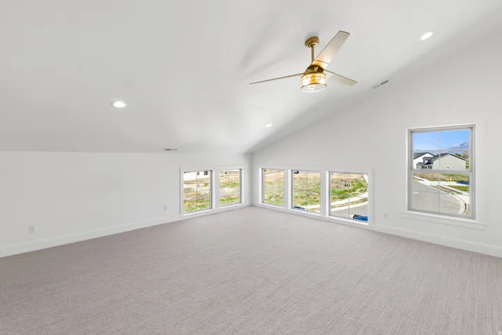 Unfurnished living room with carpet, recessed lighting, a ceiling fan, and vaulted ceiling