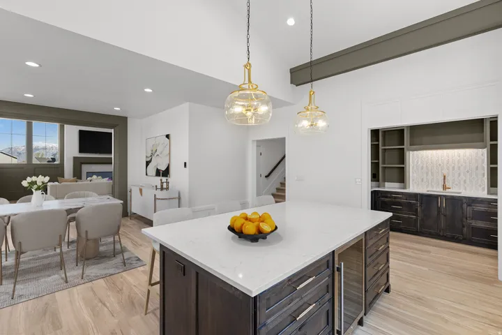 Kitchen with dark wood finish cabinets, open floor plan, light stone countertops, a kitchen island, and a kitchen breakfast bar