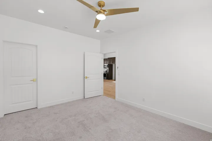 Unfurnished bedroom with light colored carpet, ceiling fan, and recessed lighting