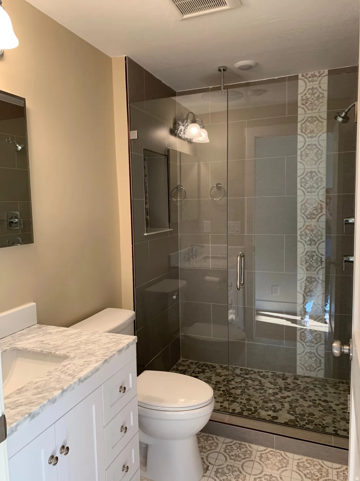 Bathroom featuring vanity, a stall shower, and light tile patterned floors