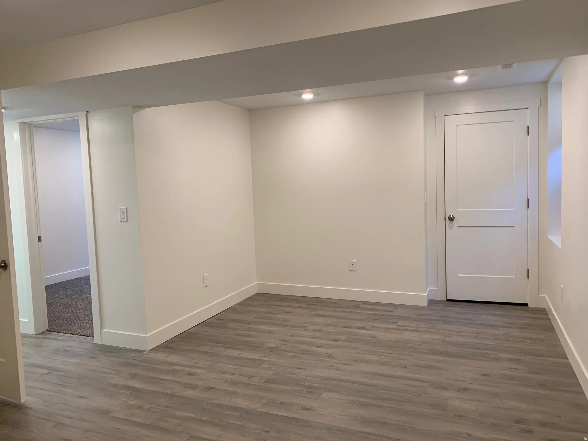 Finished below grade area featuring dark wood-type flooring and recessed lighting