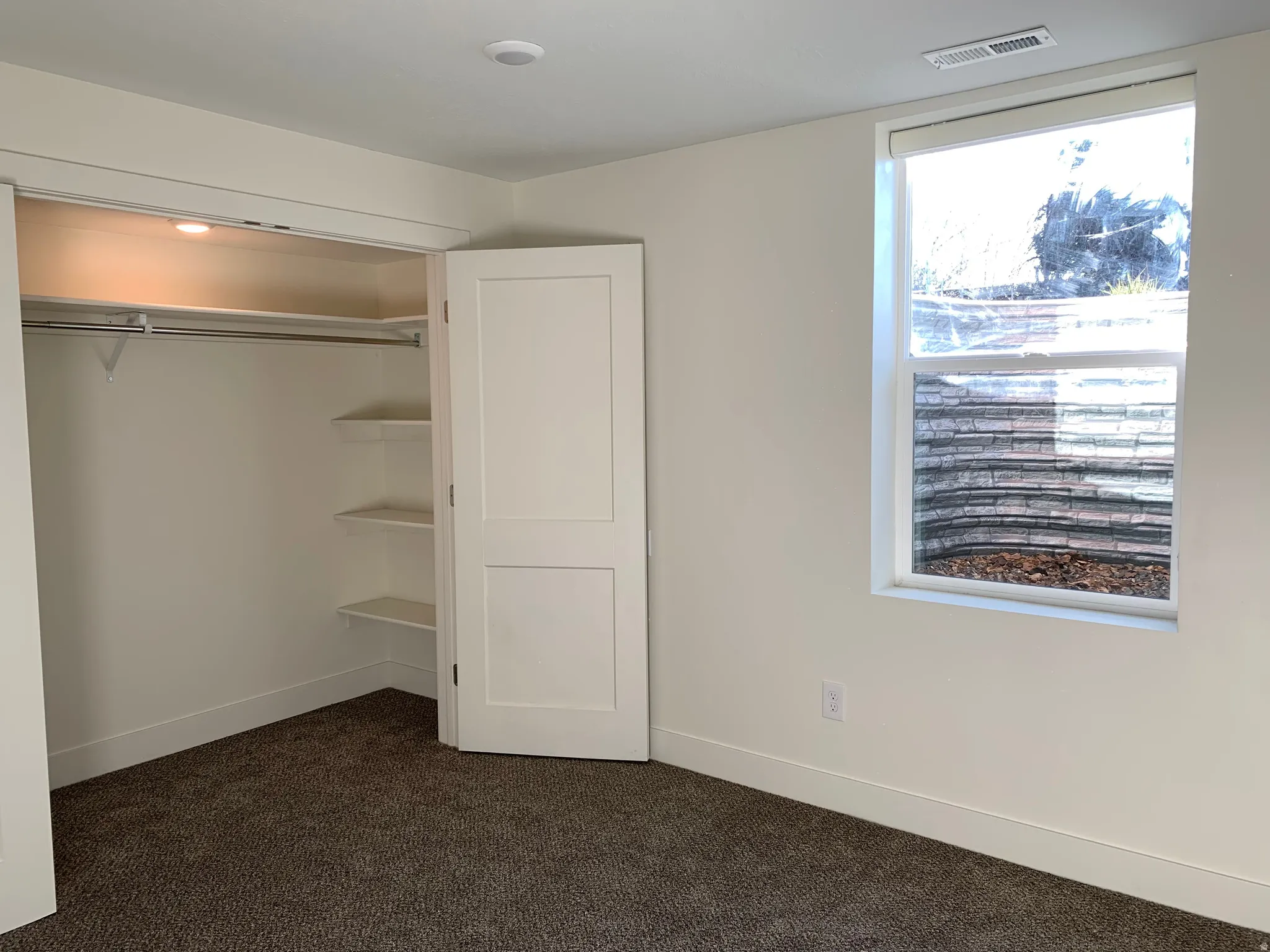 Unfurnished bedroom featuring dark carpet and a closet
