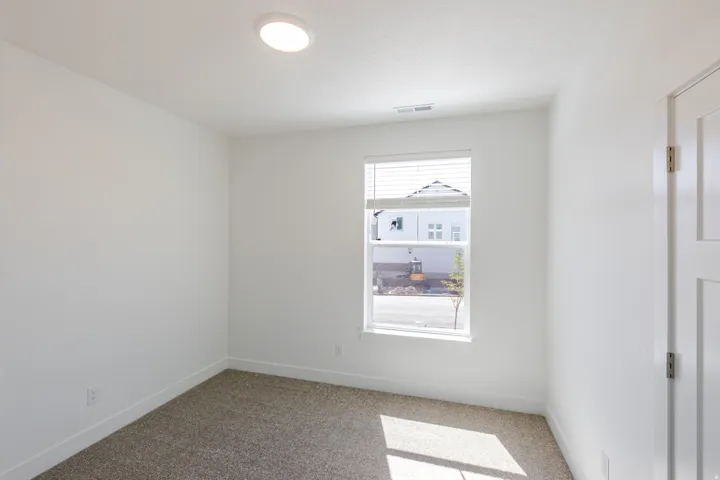 Recessed ceiling lighting, white interior paint, carpeted flooring, window with blinds, and a white interior door