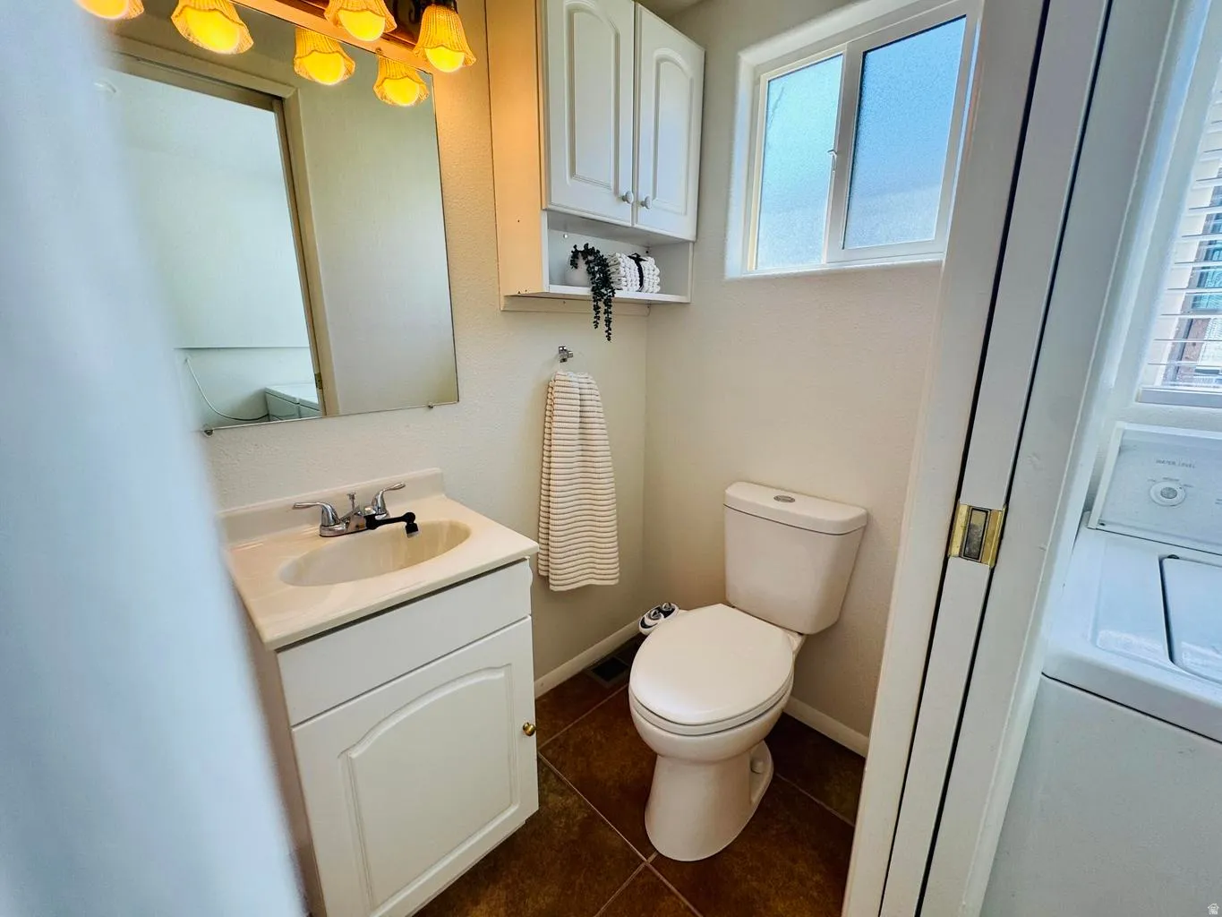 Bathroom featuring vanity and dark tile patterned flooring
