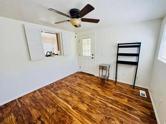 Entrance foyer with a ceiling fan, a textured ceiling, and dark wood-style flooring