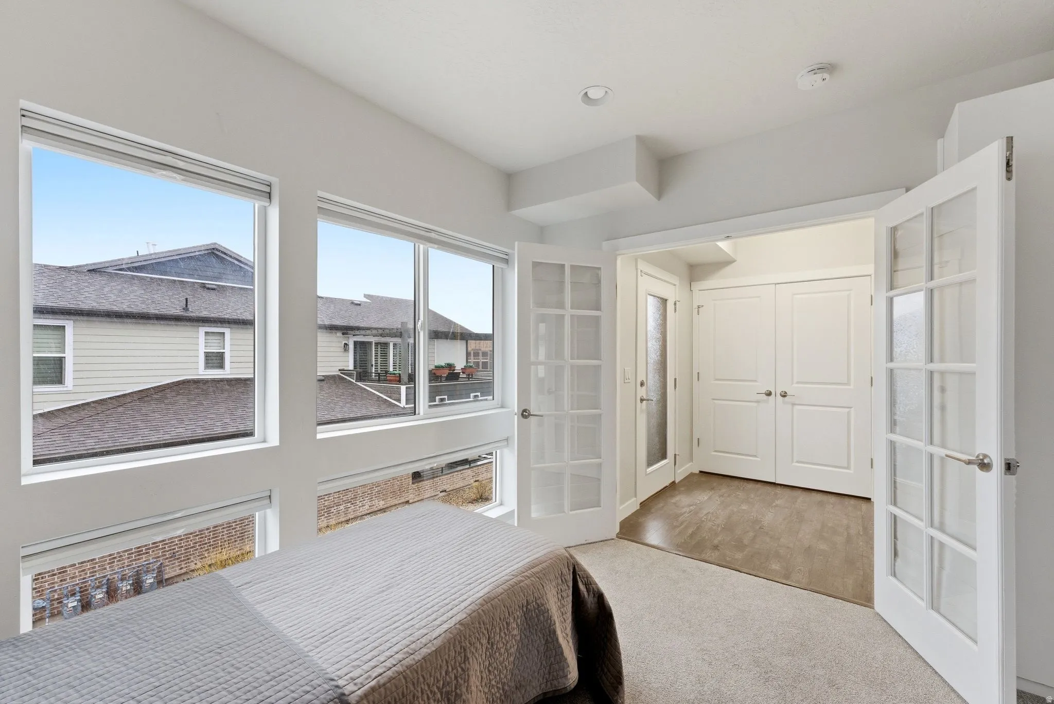 Bedroom with french doors and light carpet