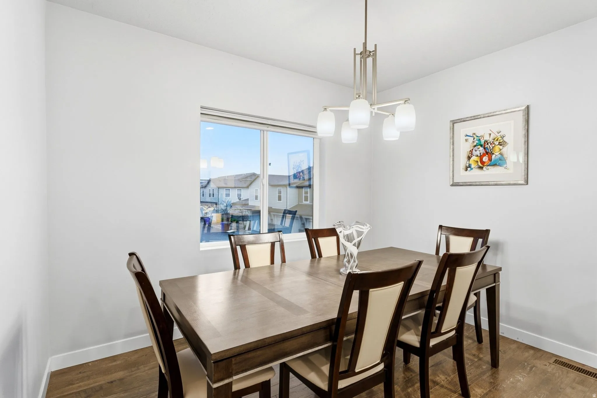 Dining space with dark wood-style floors and hanging lights