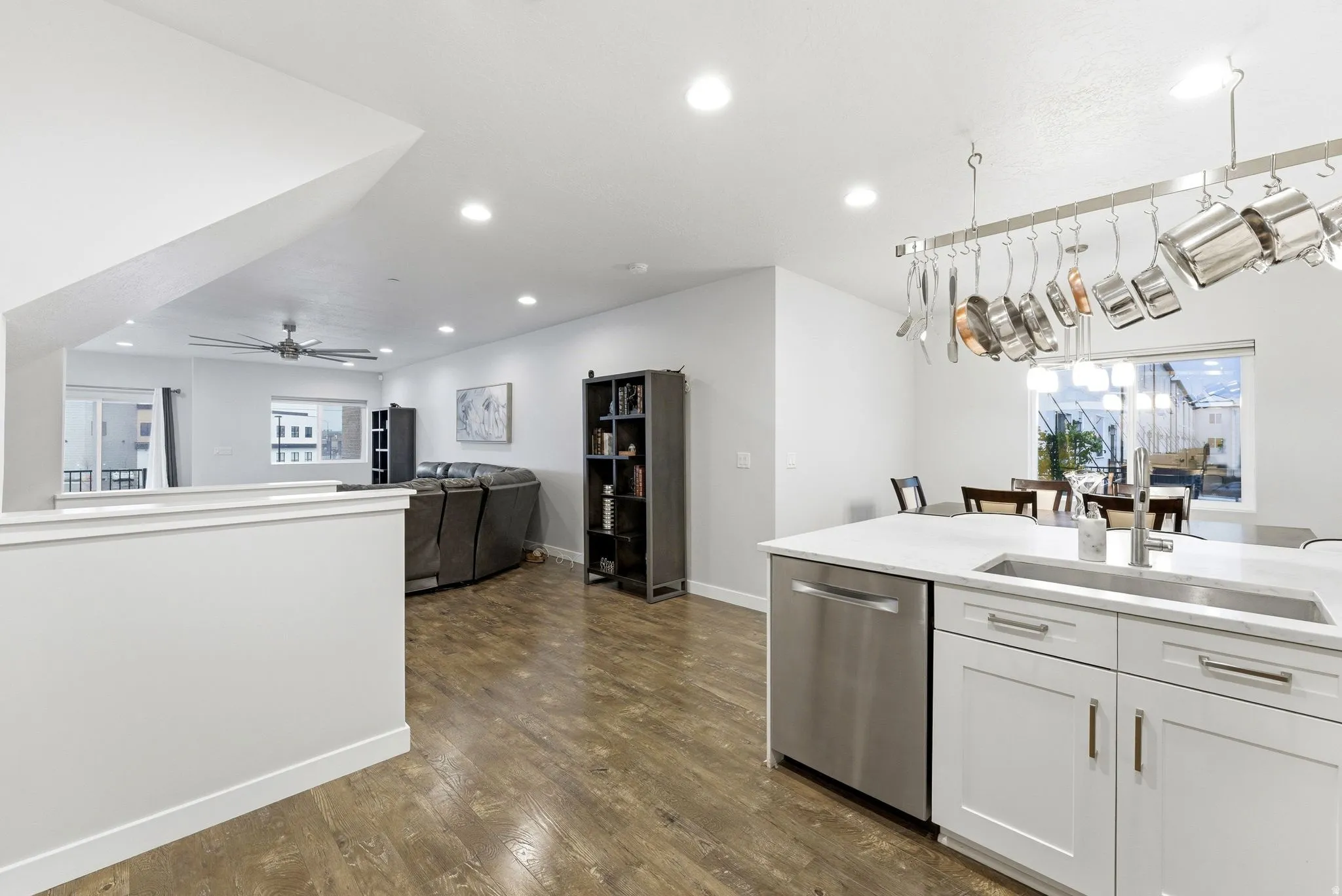 Kitchen with open floor plan, white cabinetry, dishwasher, and healthy amount of natural light