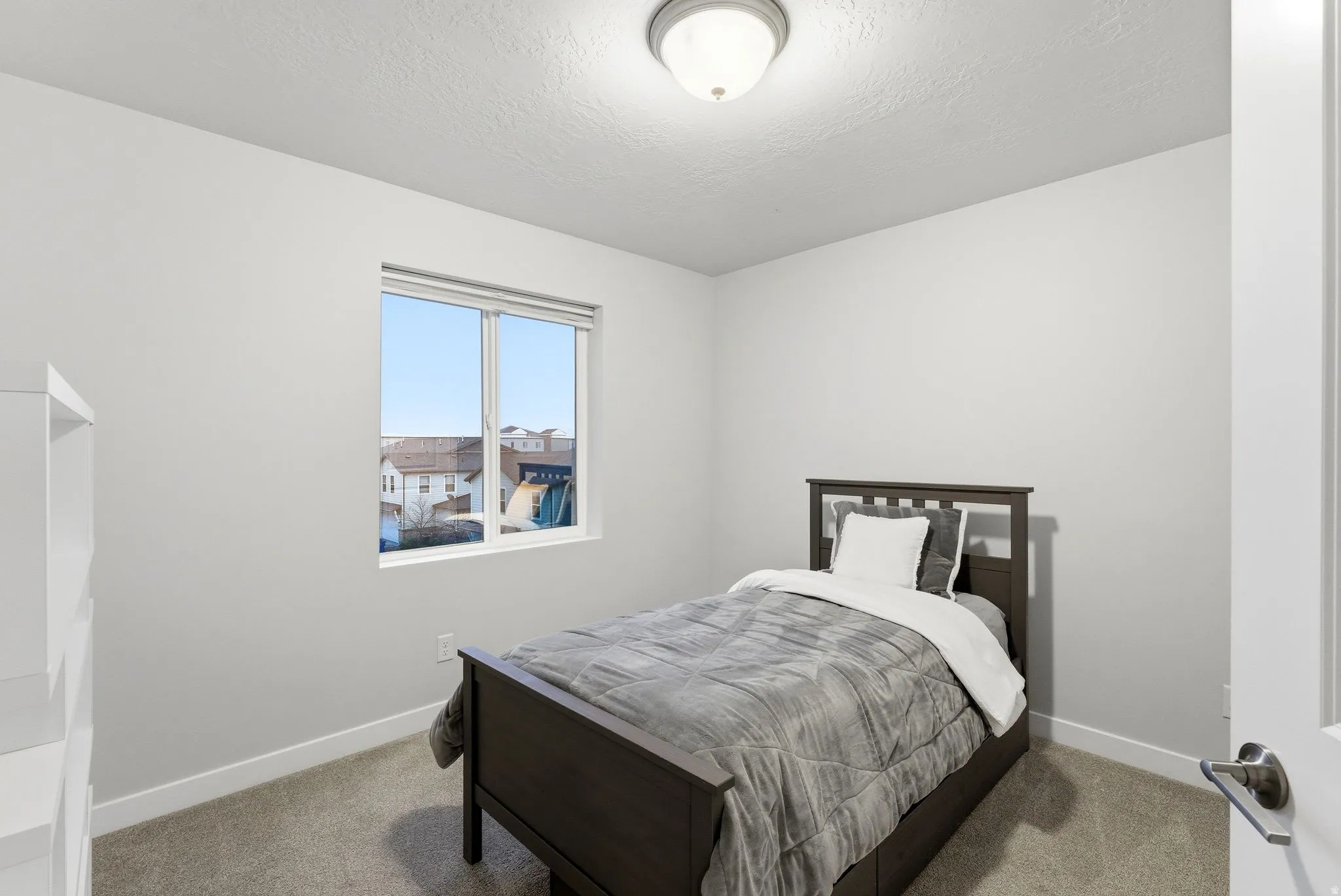 Bedroom featuring light carpet and a textured ceiling