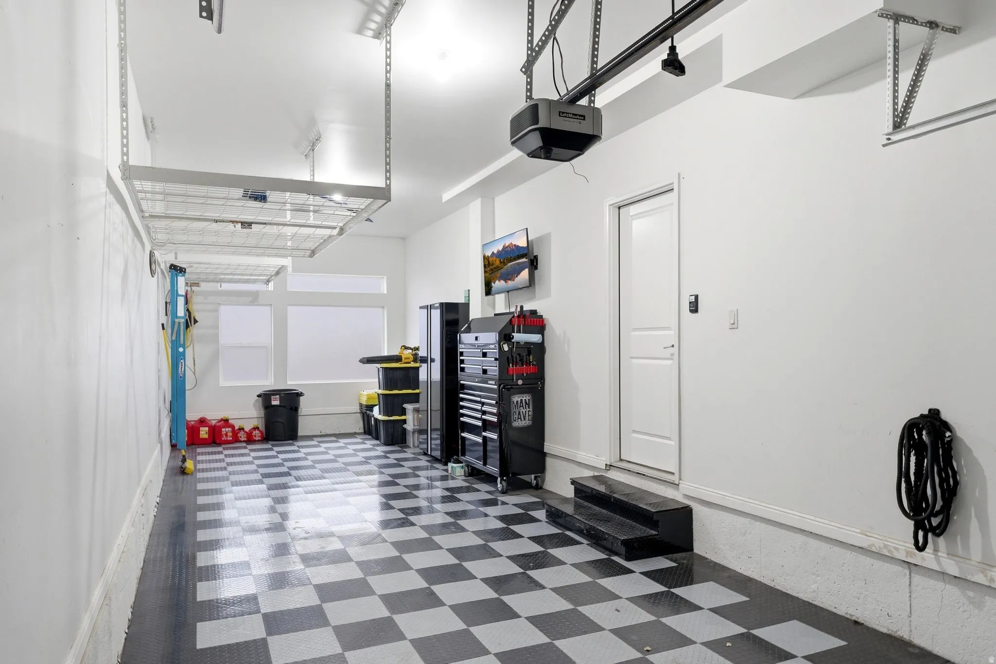 Garage featuring a garage door opener and baseboards
