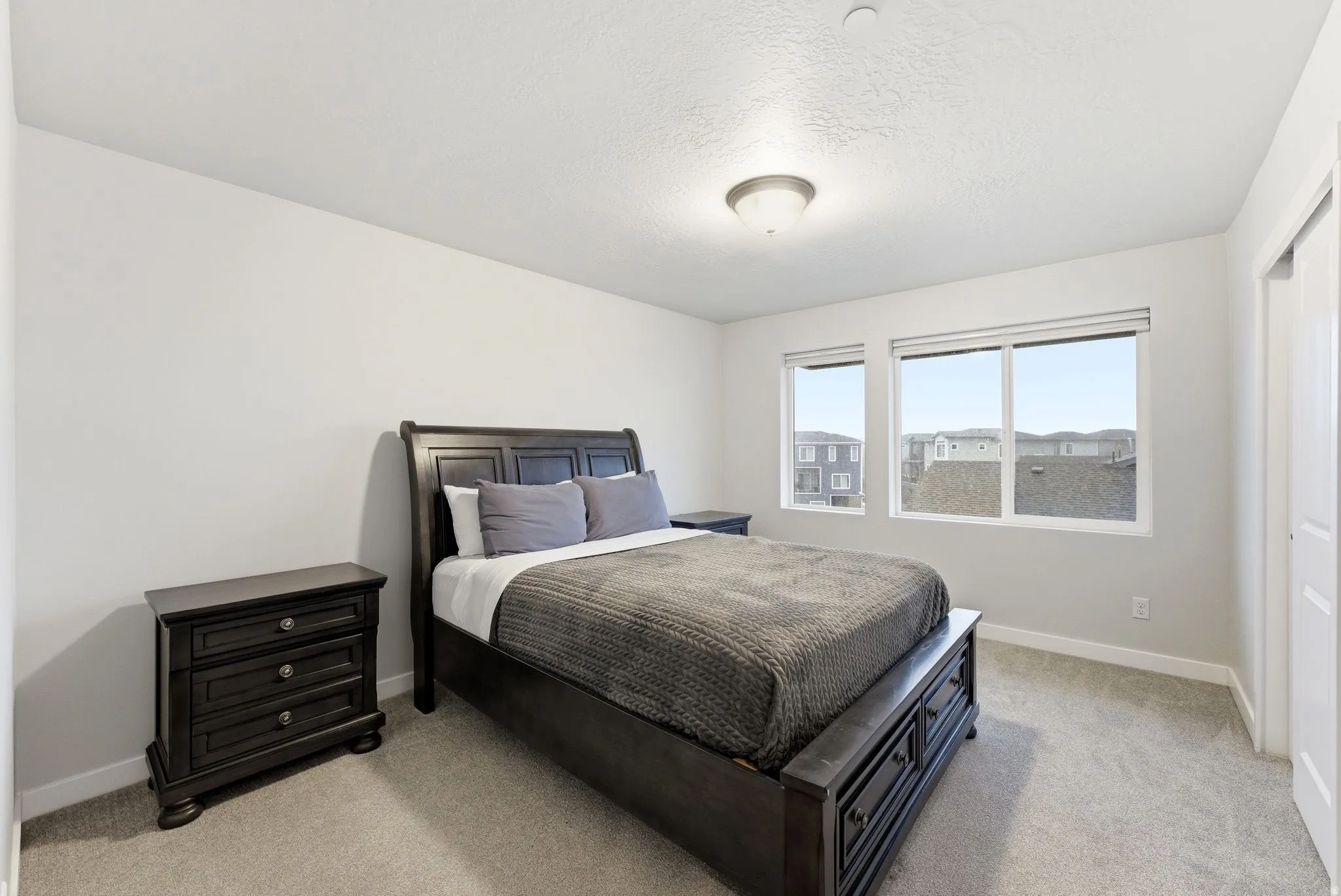 Bedroom featuring light colored carpet and a textured ceiling