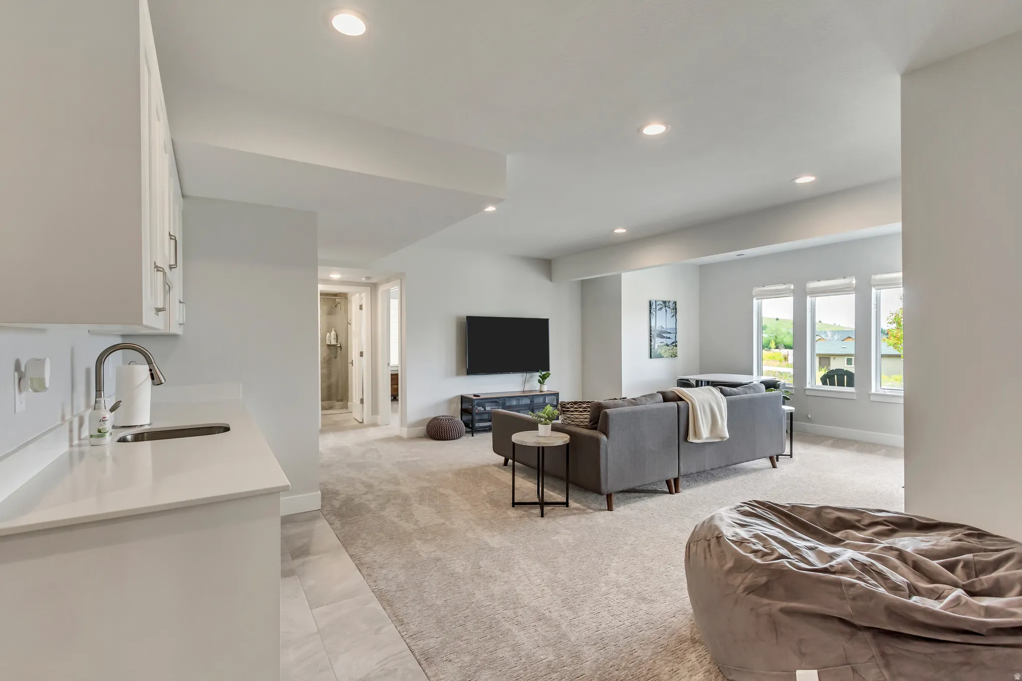 Living area featuring light colored carpet and recessed lighting