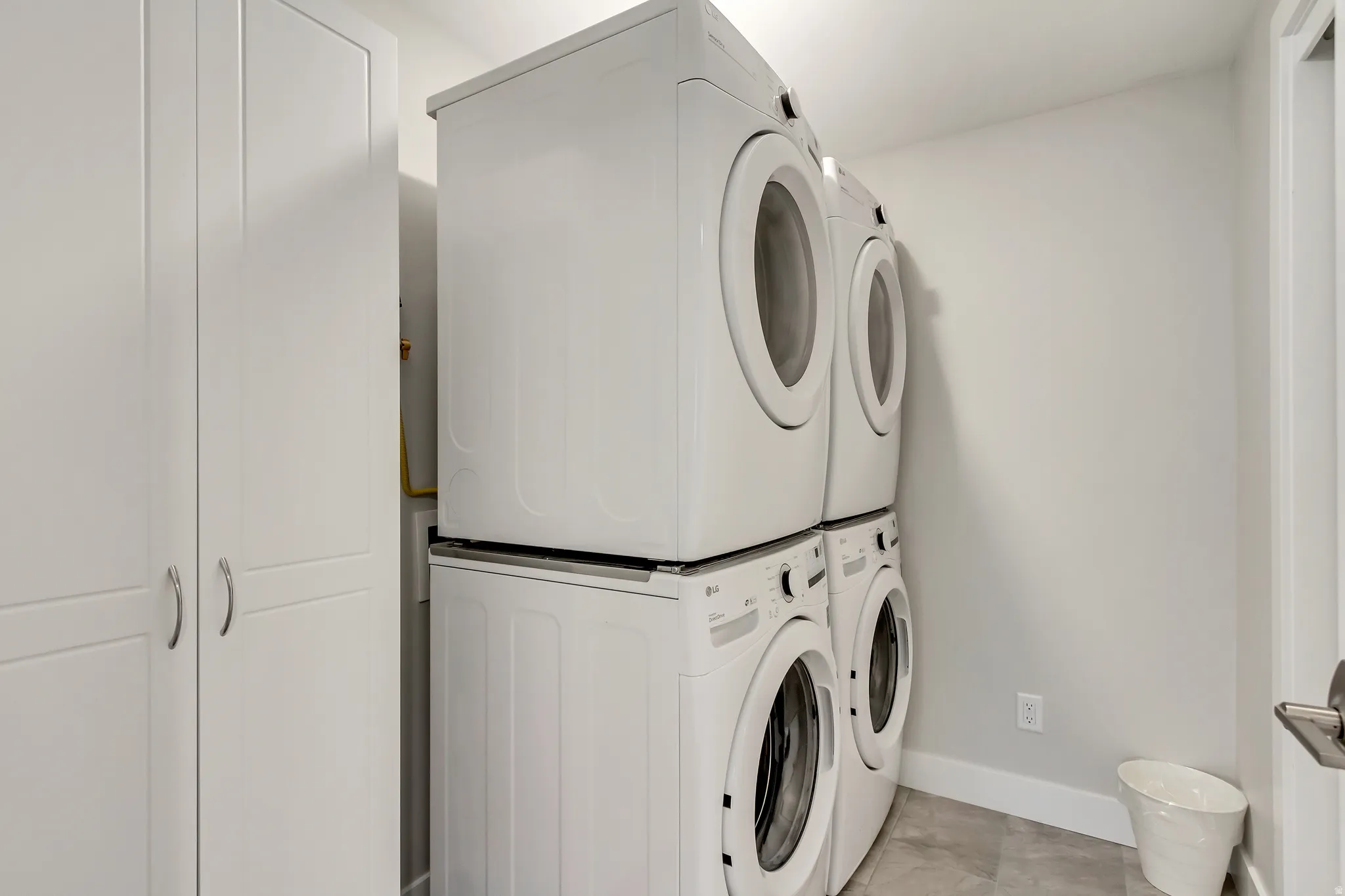Laundry area featuring baseboards and stacked washer and dryer