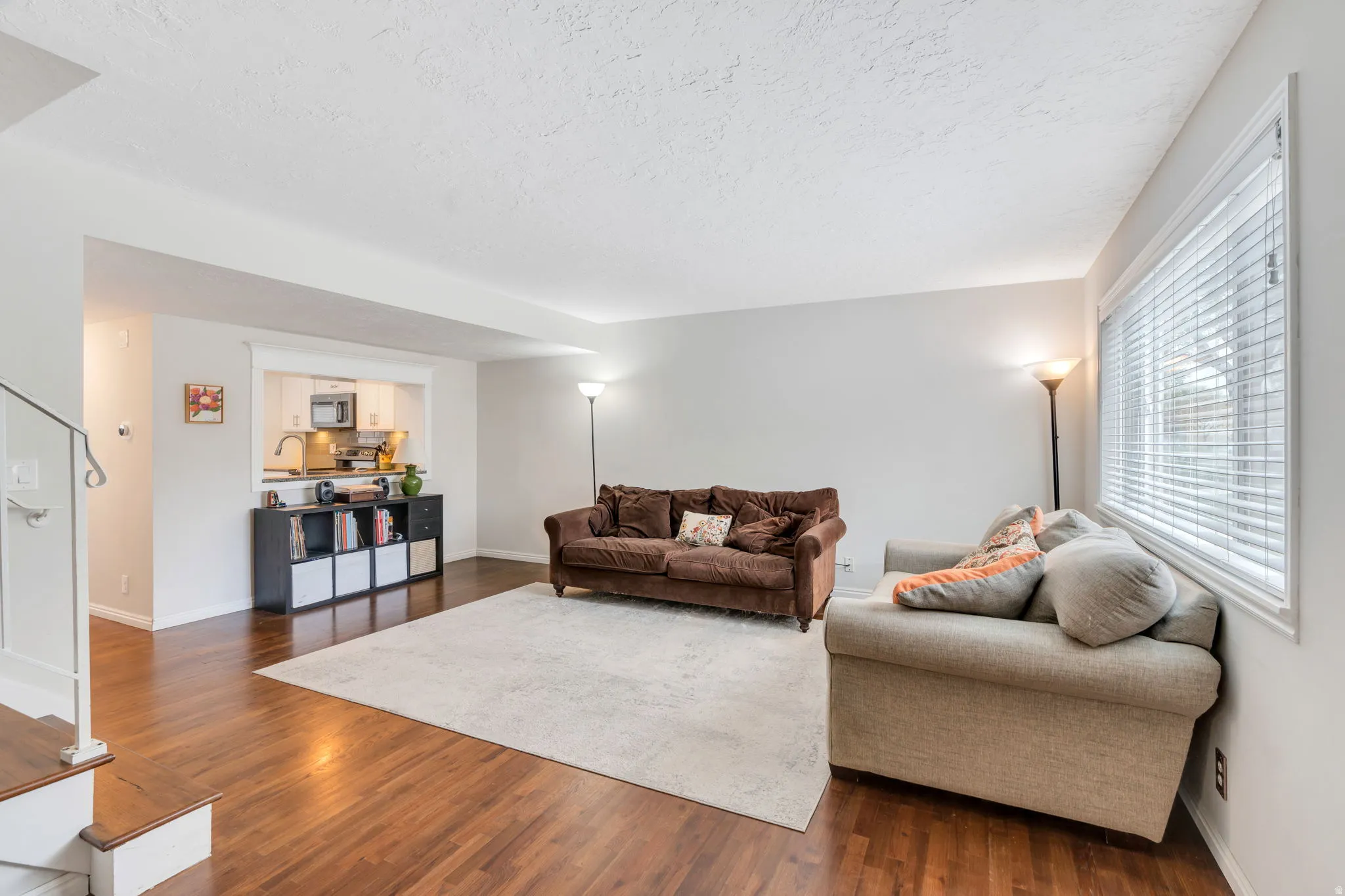 Living room with dark wood-style flooring and a textured ceiling
