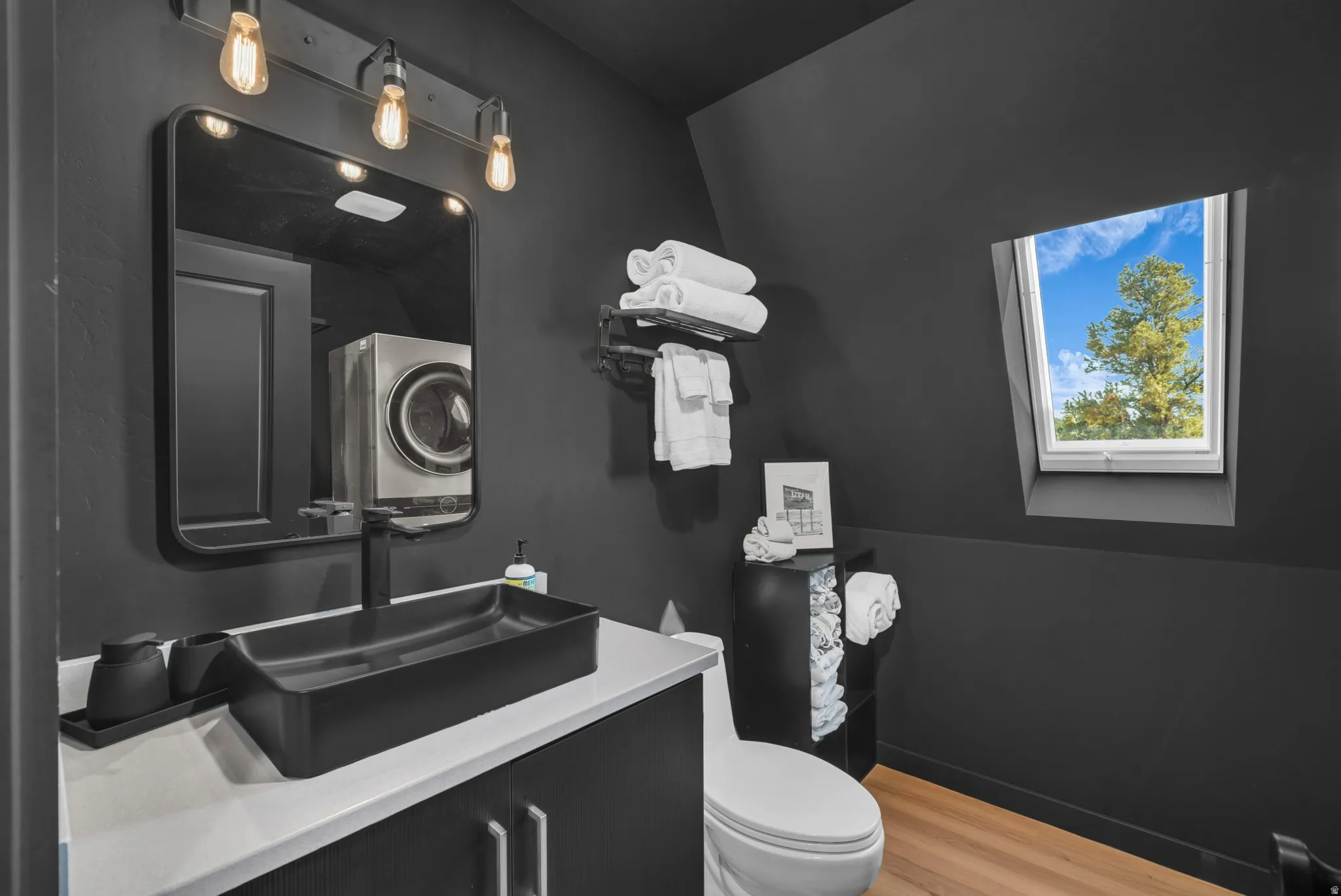 Half bath with light wood-type flooring and vanity