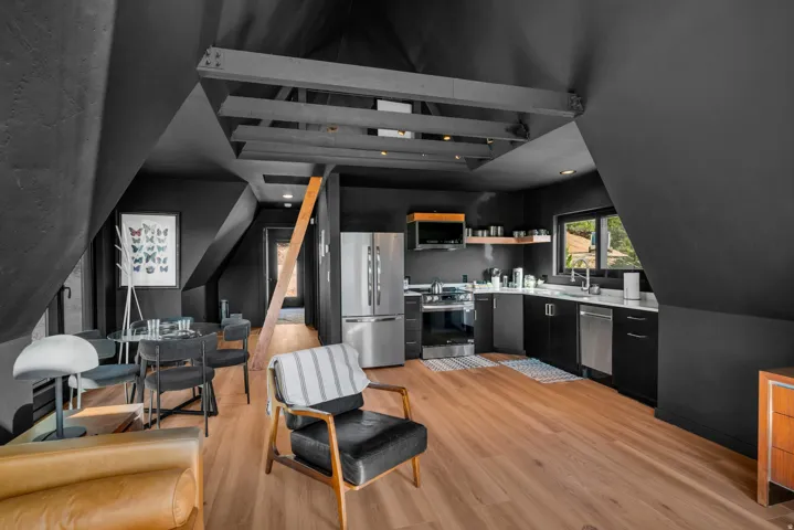 Kitchen with stainless steel appliances, light countertops, dark cabinetry, light wood-style floors, and recessed lighting