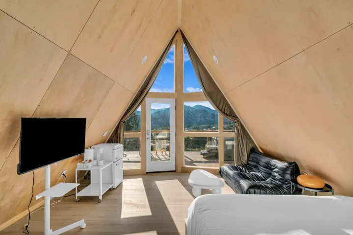 Bedroom with a mountain view, wood finished floors, and access to exterior