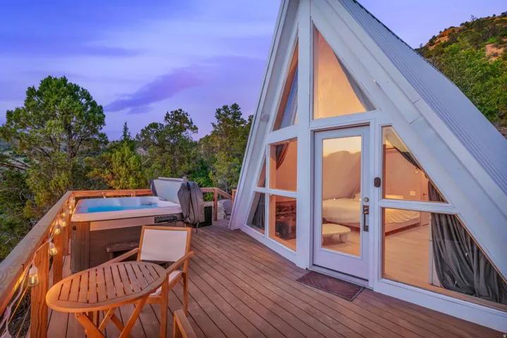 Deck at dusk featuring a hot tub