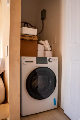 Laundry area featuring washer / clothes dryer and light wood-style floors