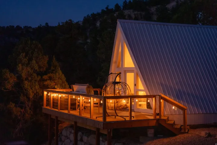 Back of house at night featuring a deck