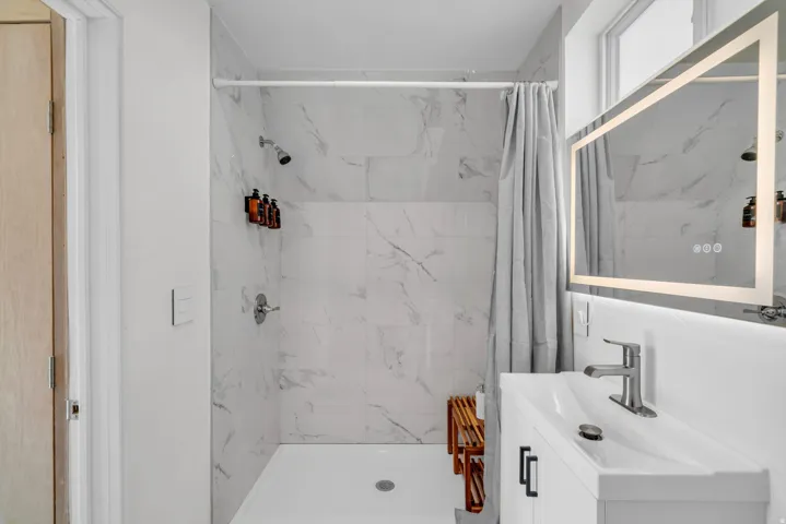 Full bathroom with vanity and a shower stall
