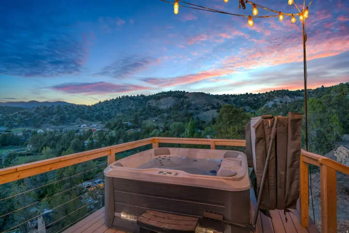 Wooden terrace featuring grilling area, a mountain view, and a hot tub