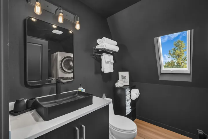 Half bath with light wood-type flooring and vanity